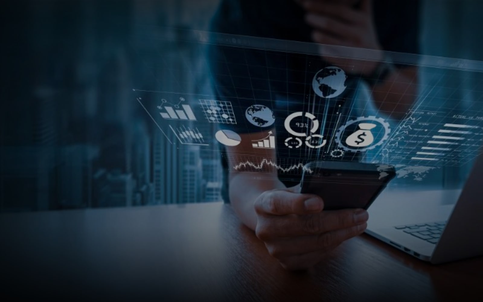 Visuel fintech Fincome - homme tenant un smartphone, ordinateur portable sur le bureau et hologramme central regroupant icônes finance et analytics (globes, engrenage, graphiques, dollar) sur fond de skyline urbain bleuté