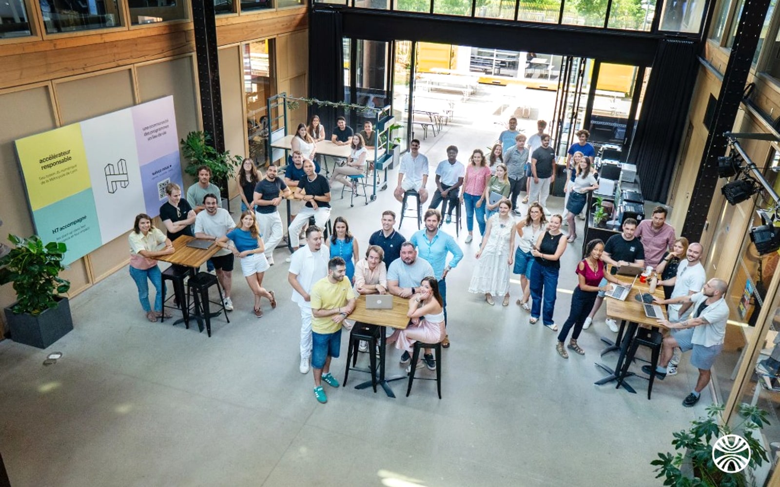 Photo de groupe de l'équipe Hupso réunie dans leur espace de travail au H7 à Lyon - vue plongeante depuis la mezzanine
