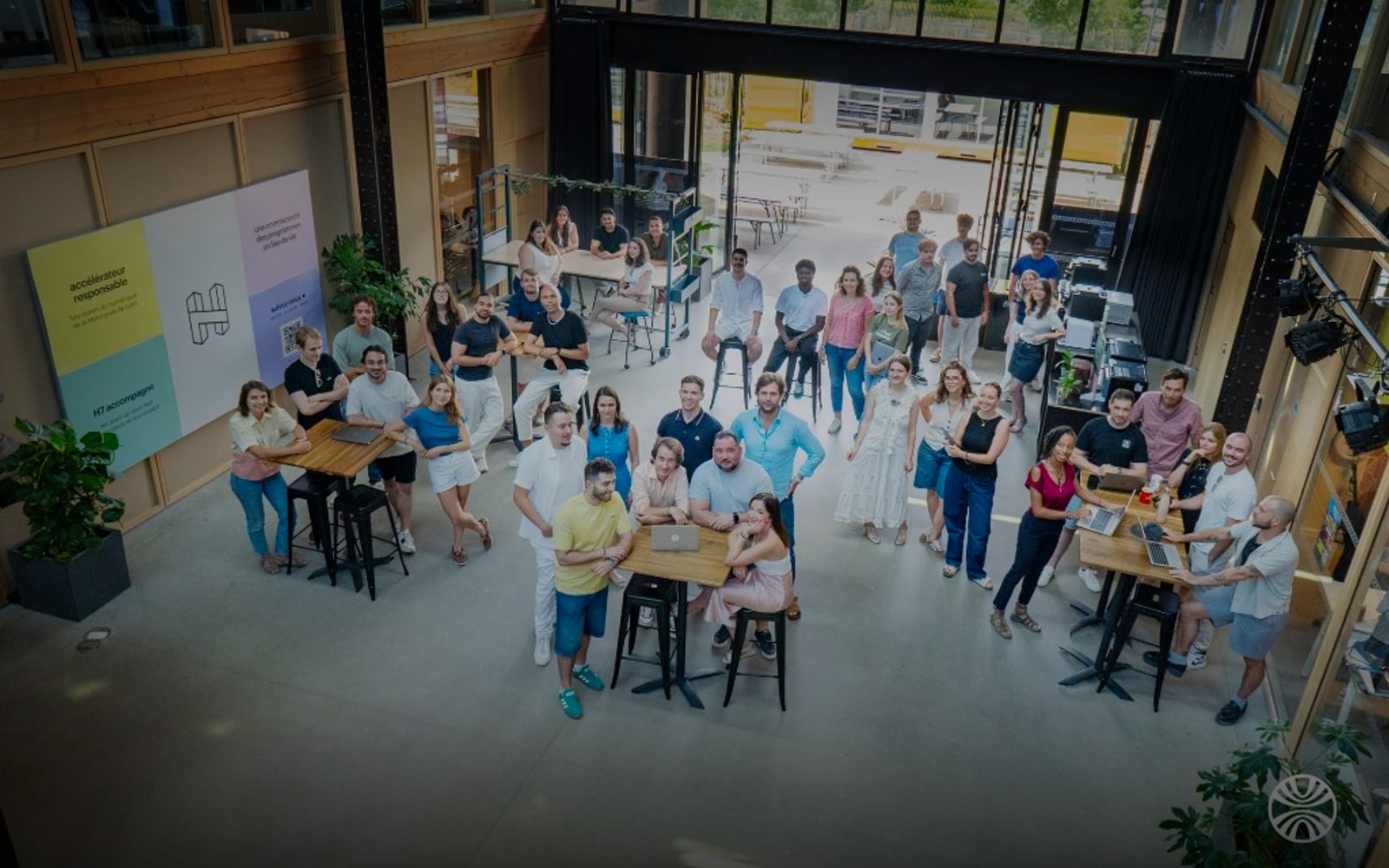 Photo de groupe de l'équipe Hupso réunie dans leur espace de travail au H7 à Lyon - vue plongeante depuis la mezzanine