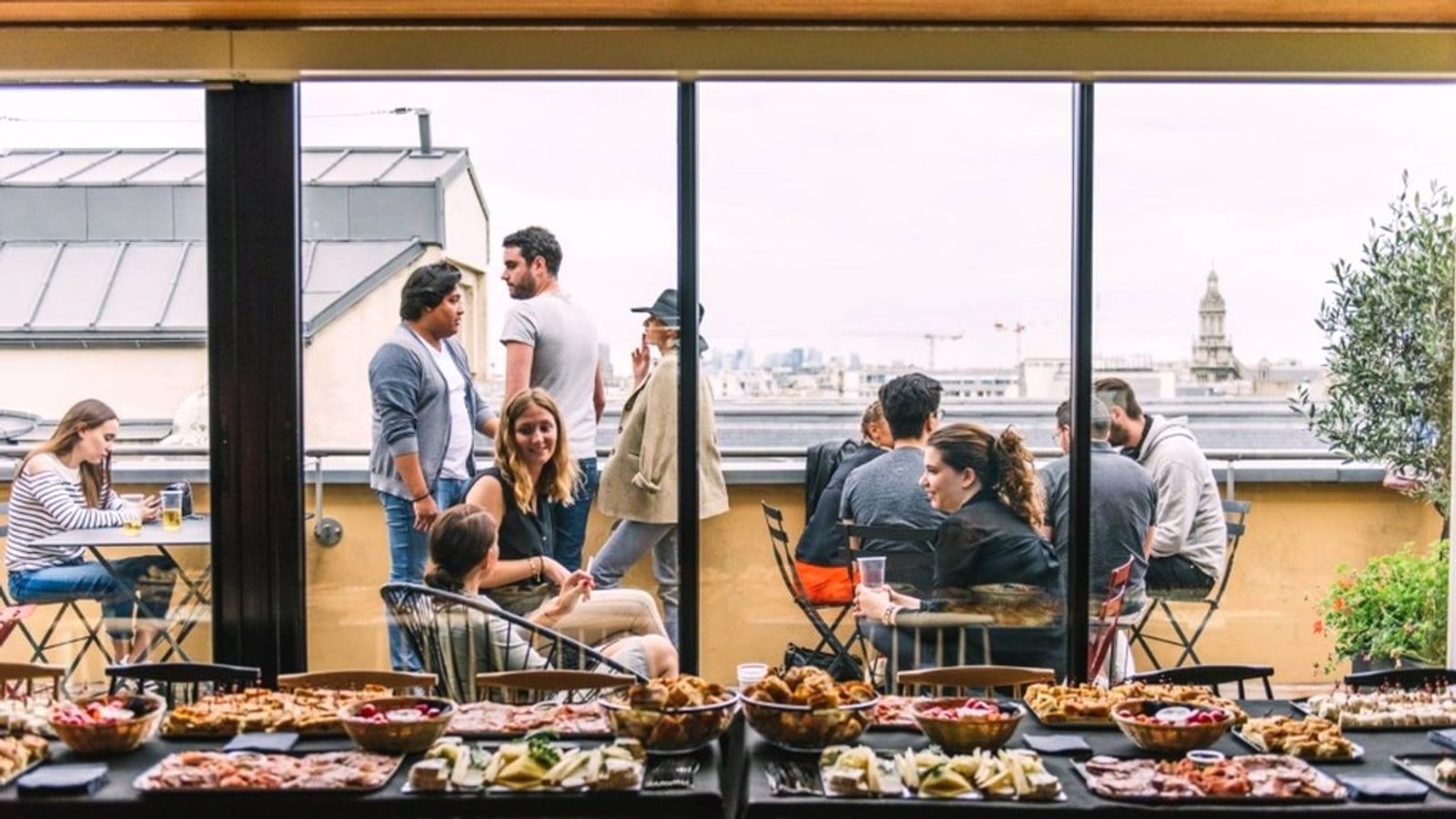 Buffet traiteur Le Vélo du Soir devant une terrasse parisienne avec vue sur les toits