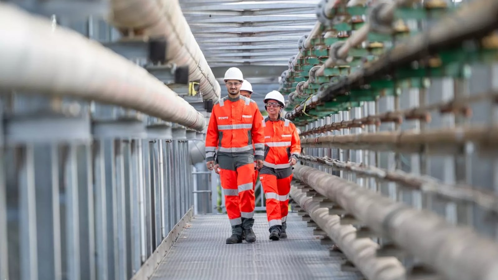 Techniciens Veolia SARP Industries en équipement de sécurité sur une passerelle industrielle